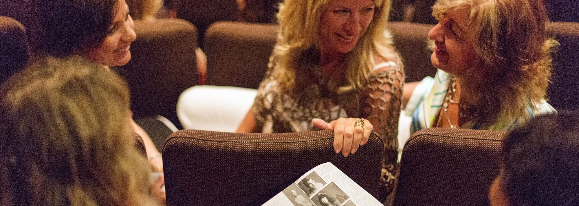 Ladies in the theatre with a house programme